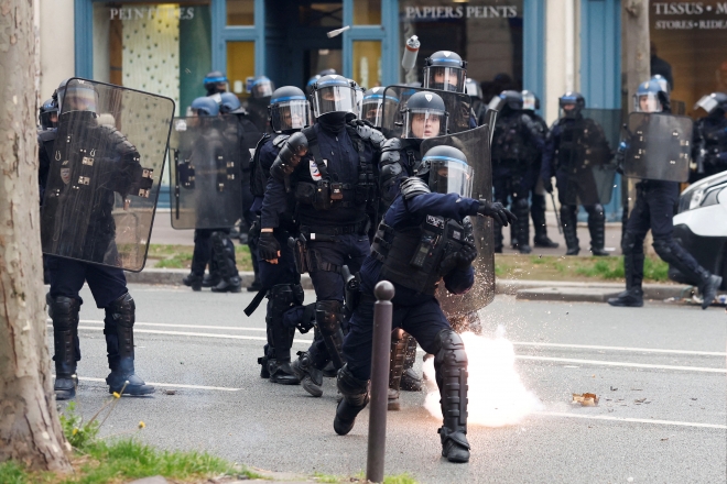 프랑스 경찰 기동대원들이 15일(현지시간) 파리에서 열린 제8차 연금개혁법안 반대 시위에서 최루탄을 던지고 있다.  파리 로이터 연합뉴스