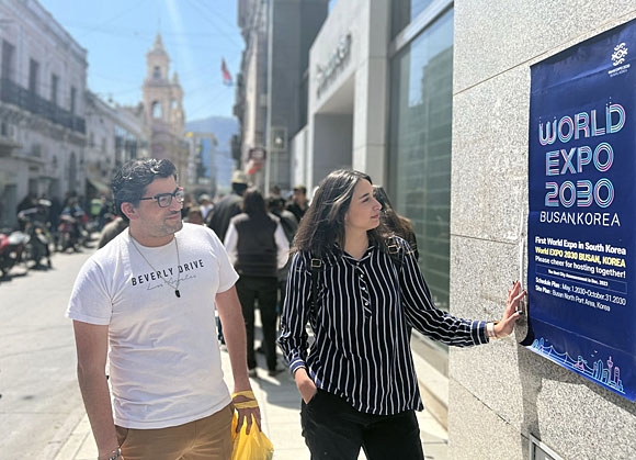 아르헨티나 살타주(州) ‘7월 9일 광장(Suare 9 de Julio)’ 앞 역사박물관을 따라 걷고 있는 두 명의 관광객이 ‘2030 부산세계박람회’ 배너를 보고 있다. 포스코 제공