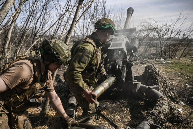 우크라이나 병사가 23일(현지시간) 동부 격전지 바흐무트에서 M119 곡사포에 장착한 105mm 포탄을 발사하고 있다. 바흐무트 AFP 연합뉴스