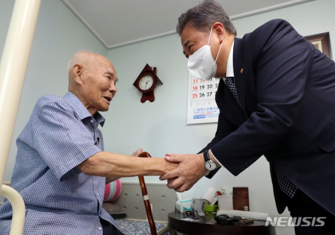 박진 외교부 장관이 지난해 9월 일제 강제동원 피해자 이춘식(98) 할아버지 자택인 광주 광산구 우산동 한 아파트를 방문한 자리에서 할아버지의 손을 잡고 있다. 광주 뉴시스