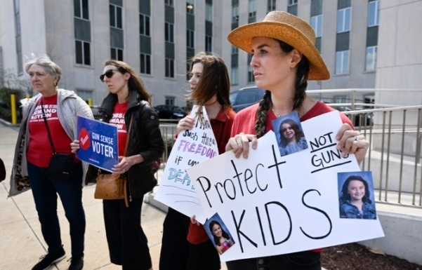 미 테네시주 내슈빌 의회 앞에서 딸의 사진이 붙은 손팻말을 든 여성이 다른 운동가들과 함께 총기 규제를 촉구하고 있다(기사 내용과 관련 없음). AP 뉴시스