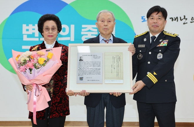 조선호(왼쪽 세번째) 경기소방재난본부장이 31일 김일남 방공단원의 장남 김영일(왼쪽 두번째)씨 부부에게 고인의 사직원서 영인본을 전달하고 기념사진을 찍고 있다.  경기소방재난본부 제공