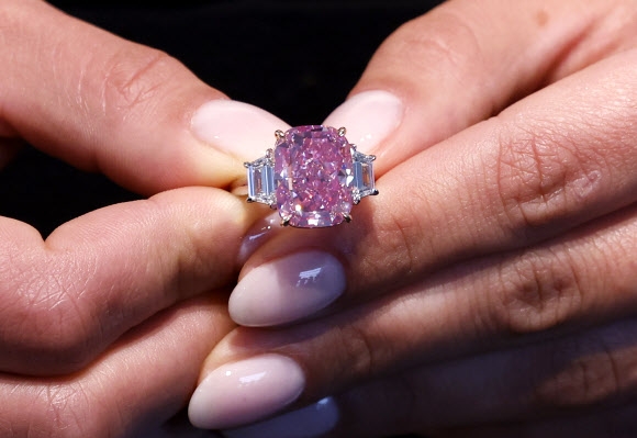 지난 27일(현지시간) 미국 뉴욕의 소더비에서 한 여성이 10.57캐럿짜리 핑크 다이아몬드 반지를 끼고 포즈를 취하고 있다. ‘이터널 핑크’(Eternal Pink)라는 이름의 이 다이아몬드는 오는 6월 8일 소더비 경매에 나와 3500만 달러(약 458억원)에 낙찰될 것으로 예상된다. 2023.03.27 UPI 연합뉴스