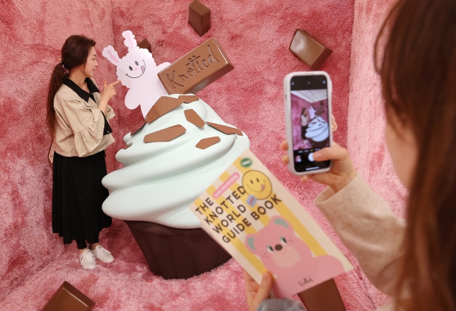 지난달 31일 서울 송파구 롯데월드몰에 문을 연 도넛 브랜드 ‘노티드 ’ 매장을 찾은 시민들이 전시된 컵케이크 모형과 함께 기념촬영을 하고 있다.