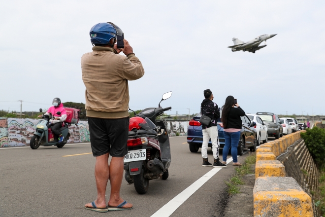 9일 대만 상공을 나르는 자국 전투기를 시민들이 보고 있다.  EPA 연합뉴스