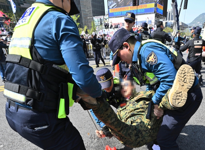 해병대 군복을 입은 한 중년 남성이 지난달 9일 서울 중구 세종대로 일대에서 진행한 부활절 퍼레이드를 보고 달려들었다가 경찰의 제지를 받고 있다. 홍윤기 기자