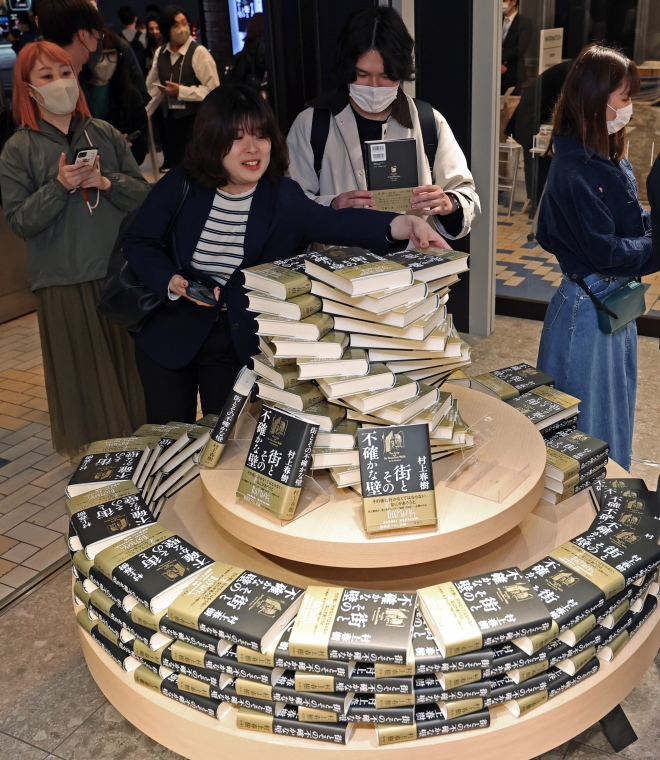 무라카미 하루키의 6년 만의 신작 장편소설 ‘거리와 그 불확실한 벽’이 발간된 13일 0시에 맞춰 판매를 시작한 도쿄 신주쿠의 대형 서점인 기노쿠니야서점 본점에 몰려든 하루키의 팬들이 그의 신작을 구입하고 있다. 도쿄 EPA 연합뉴스