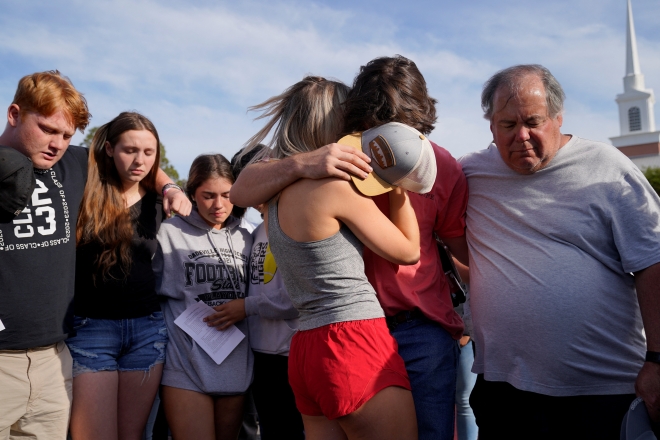 16일 미국 앨라배마주 데이드빌에서 시민들이 전날 발생한 십대 생일 파티 총격 사건을 애도하며 서로를 위로하고 있다. 로이터 연합뉴스
