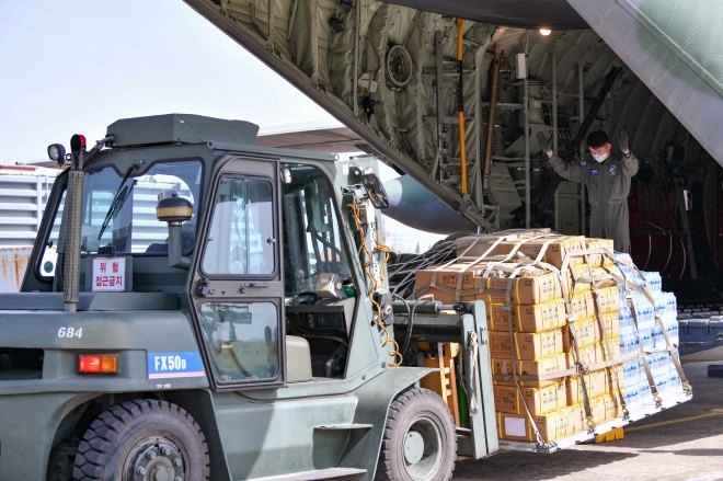21일 공군 제5공중기동비행단 장병들이 수단 교민철수 해외임무에 필요한 물자를 C-130J 수송기에 적재하고 있다.   국방부 제공