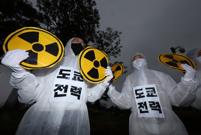 6일 오전 서울 용산 대통령집무실 앞에서 한국YWCA 연합회 회원들이 방호복을 입고 후쿠시마 오염수 방류 저지를 촉구하며 포즈를 취하고 있다. 연합뉴스