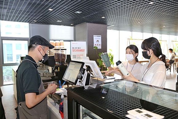DL이앤씨 직원들이 서울 종로구 디타워의 D라운지카페에서 일회용컵 대신 개인 컵을 사용해 음료를 주문하고 있다. DL이앤씨 제공