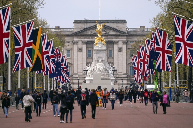 영국 국왕 찰스 3세의 대관식을 일주일여 앞둔 27일(현지시간) 영국 런던에서 영국과 영연방 국가의 국기가 걸린 몰을 사람들이 걷고 있다.  런던 AP 연합뉴스