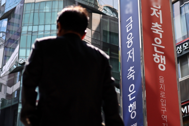 한 시민이 1일 서울 시내의 한 저축은행 앞을 지나가고 있다. 가계와 기업의 대출 연체율이 가파르게 치솟으면서 선제적인 위험 관리 중요성이 커졌다. 연합뉴스