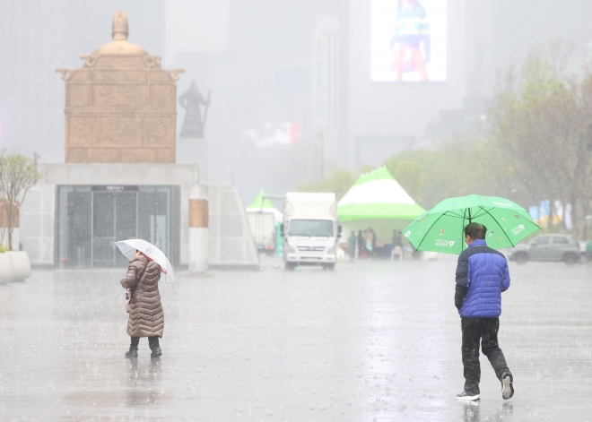 11일 오후 서울 광화문광장을 지나는 시민들이 갑자기 쏟아지는 비를 뚫고 걸어가고 있다. 2023. 4. 11 연합뉴스
