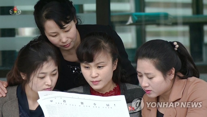 북한 노동신문 기사를 읽고 있는 평양 시민들. 조선중앙TV 연합뉴스