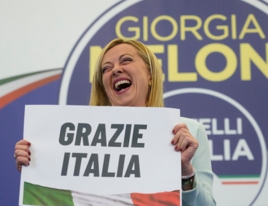 멜로니 총리가 지난해 9월25일(현지시간) 로마에 자리한 당 선거본부에서 “고맙습니다 이탈리아”라고 쓰인 손팻말을 들고 활짝 웃고 있다. 이날 치러진 이탈리아 조기 총선에서 극우 이탈리아 형제당이 주축이 된 우파연합이 승리해 사상 첫 여성 총리가 탄생했다. AP 뉴시스