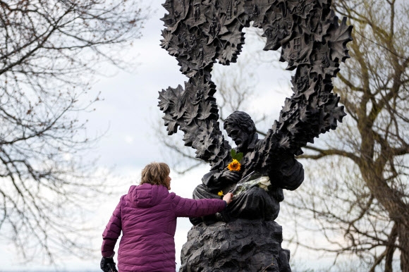 캐나다 여성 리 마주리가 전날 세상을 등진 고든 라이트풋이 태어난 온타리오주 오릴리아에 세워진 그의 동상에 꽃을 바치고 있다. 오릴리아 로이터 연합뉴스