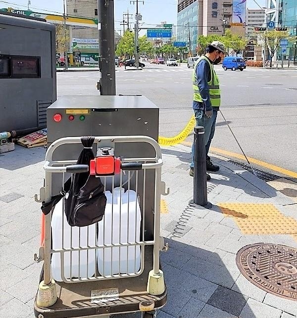 영등포구 관계자가 악취를 줄이기 위해 빗물받이에 탈취제를 투입하고 있다. 영등포구 제공