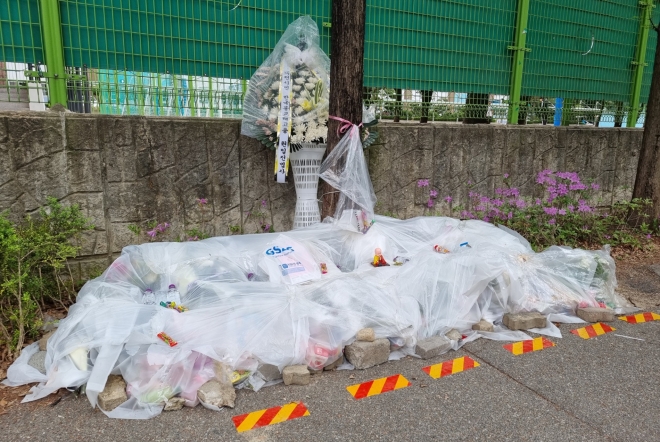 지난달 11일 배승아양 사고 직후 시민들이 사고 장소에 놓은 꽃과 편지 등이 비에 젖을까봐 비닐을 씌워놓았다.