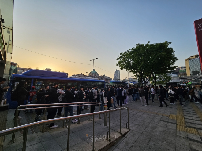 지난달 27일 오후 5시쯤 서울 중구 서울역 버스종합환승센터에서 승객들이 긴 줄을 이루며 광역버스를 기다리고 있다. 광역버스가 대거 정차하는 환승센터에는 이날 퇴근시간이 임박할수록 버스를 타는 승객보다 기다리는 승객이 더 많아져 펜스 너머까지 대기줄이 이어졌다. 홍인기 기자