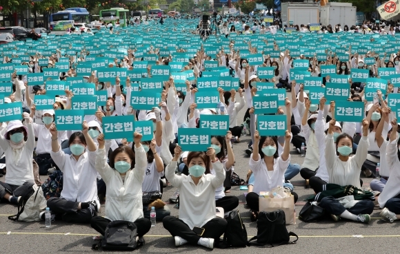 대한간호협회 간호사들이 12일 오후 서울 동화면세점 앞 세종대로에서 열린 국제간호사의 날 기념 집회에서 피켓을 들고 간호법 제정을 촉구하고 있다. 2023.5.12 뉴스1