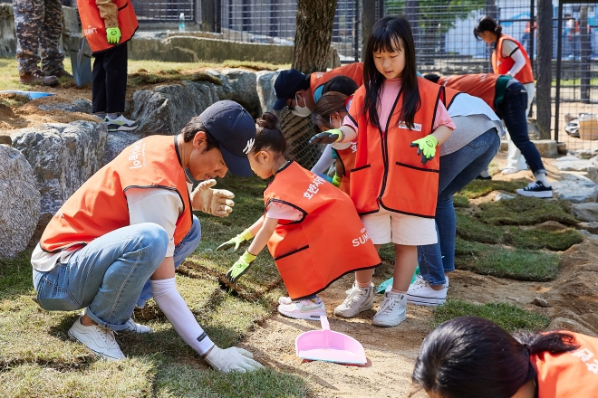 호반그룹  임직원 봉사단원과 가족들이 서울대공원에 천연 잔디 심기 봉사를 하고 있다. 호반그룹 제공