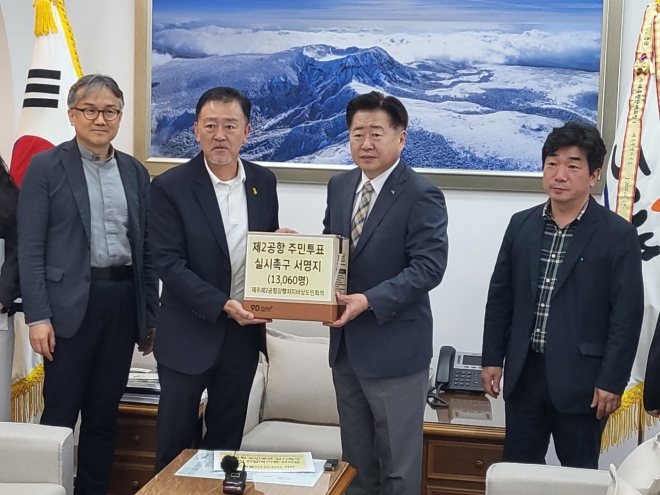 제주제2공항강행저지비상도민회의 강원보(왼쪽 두번째) 공동집행위원장이 23일 제주도청을 방문, 오영훈 지사에게 주민투표 실시 촉구 서명서를 전달하고 있다.  제주 강동삼 기자