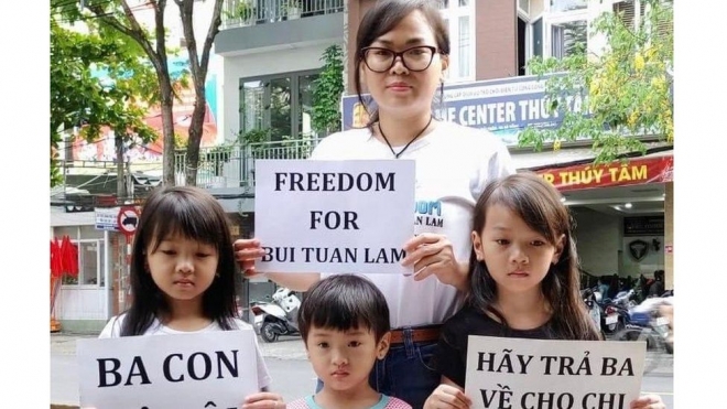 부이 투안 람의 아내와 세 딸이 남편과 아빠를 빨리 석방해 달라는 내용의 손팻말을 들어 보이고 있다. 영국 BBC 홈페이지 캡처