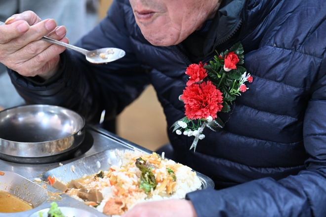 어버이날인 8일 카네이션을 가슴에 단 한 어르신이 서울 종로구 탑골공원 인근 무료 급식소에서 식사를 하고 있다. 이날 급식소 앞은 무료 급식을 받기 위한 어르신들로 붐볐다. 2023.5.8. 도준석 기자
