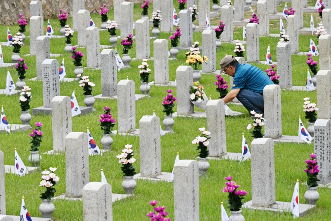 호국 보훈의 달 첫날인 1일 오전 서울 동작구 국립서울현충원을 찾은 한 시민이 묘역에 꽃을 내려놓고 있다. 2023.6.1 홍윤기 기자