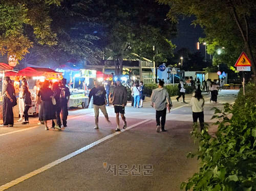 지난달 26일 여의도한강공원에 나들이 나온 시민들이 노점상 앞 자전거도로에서 줄을 서고 있다. 강동용 기자