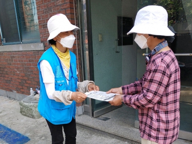 서울 성북구 ‘생활폐기물 배출 안내 전문가’(왼쪽)가 담당 지역 주민에게 올바른 생활폐기물 배출법이 적힌 안내문을 전달하고 있다. 성북구 제공
