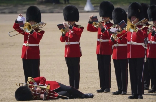 10일(현지시간) 영국 근위병이 찰스 3세 국왕의 공식 생일을 기념하는 ‘군기분열식’ 최종 리허설을 하다 실신해 쓰러져 있다. AP 연합뉴스