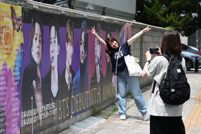 12일 오전 서울 용산구 하이브 사옥 인근에서 외국인 팬들이 방탄소년단(BTS) 데뷔 10주년 기념 그림 앞에서 사진을 찍고 있다. 2023.06.12. 도준석 기자