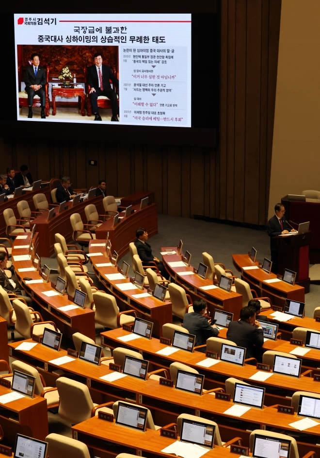 12일 국회 본회의에서 국민의힘 김석기 의원의 대정부 질문 때 민주당 이재명 대표와 주한중국대사의 회동 화면이 나오고 있다. 연합뉴스