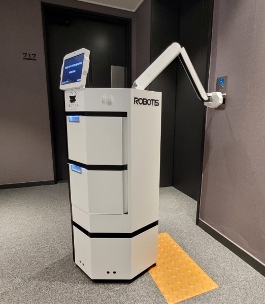 실내 자율운행 로봇인 ‘일개미’가 팔을 이용해 엘리베이터 호출 버튼을 누르는 모습. 로보티즈 제공