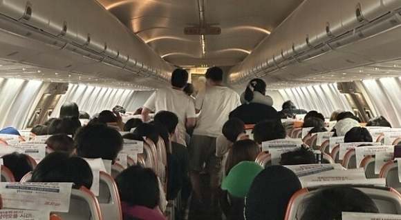 필리핀 세부를 출발해 인천으로 향하던 제주항공 여객기 내에서 20대 승객 A씨가 출입문을 개방하려고 시도하자 승객들이 이를 막고자 분주하게 움직이고 있다.네이버 카페 캡처