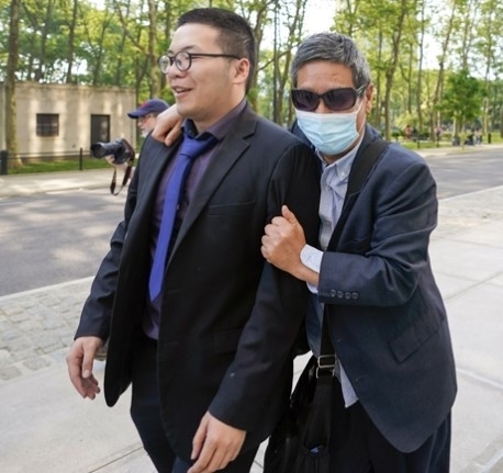 지난달 31일 미국 뉴욕 브루클린 연방지방법원에서 ‘여우사냥’ 관련자인 주융(오른쪽)이 기자들로부터 자신을 보호하고 있다. 뉴욕 AP 뉴시스