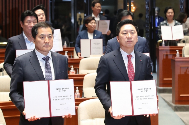 김기현(오른쪽) 국민의힘 대표, 박대출 정책위의장 등 여당 의원들이 21일 국회에서 열린 의원총회에서 ‘국회의원 불체포특권 포기 서약서’를 펼쳐 보이고 있다. 뉴스1