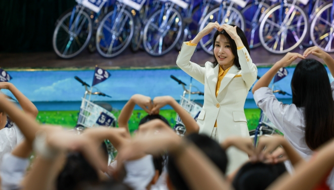 윤석열 대통령과 베트남을 국빈 방문 중인 김건희 여사가 22일(현지시간) ‘하노이 SOS 어린이마을 학교’에서 열린 ‘바이크 런(Bike Run)’ 자전거 기부 행사에서 참석자들과 손을 머리 위로 들어 하트를 그려보이고 있다. 하노이 연합뉴스