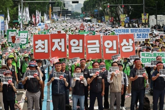 24일 서울 혜화역 인근에서 열린 ‘윤석열 정권 퇴진 전국노동자대회’에서 민주노총 회원들이 최저임금 인상 등을 촉구하는 손 피켓을 들어 보이고 있다. 연합뉴스