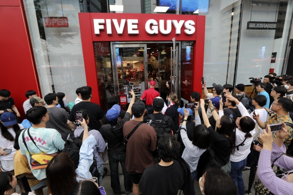 26일 개점한 서울 서초구 파이브가이즈 매장이 문을 옆자 몇 시간 동안 기다리던 시민들이 매장 앞으로 몰리고 있다. 2023.6.26 뉴시스