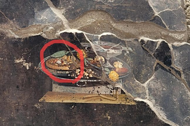 지난 25일(현지시각) 이탈리아 폼페이 유적지구 무너진 벽에서 피자처럼 보이는 음식이 그려진 벽화가 발견됐다. AFP 연합뉴스