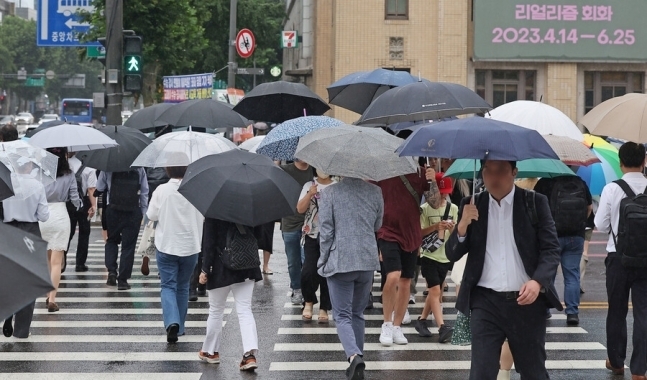 26일 오전 서울 광화문광장에서 시민들이 우산을 쓴 채 횡단보도를 지나고 있다. 2023.6.26 연합뉴스