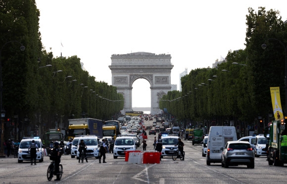프랑스 경찰관들이 2일(현지시간) 파리에서 가장 번화한 샹젤리제 거리를 지나가는 차량들을 검문하고 있다. 파리 신화 연합뉴스