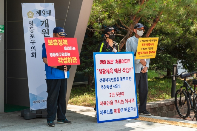 지난 6일 영등포구의회 9대 개원 1주년 기념식장 앞에서 주민들이 구의회의 추경 삭감에 반대하는 피켓 시위를 벌이고 있다.