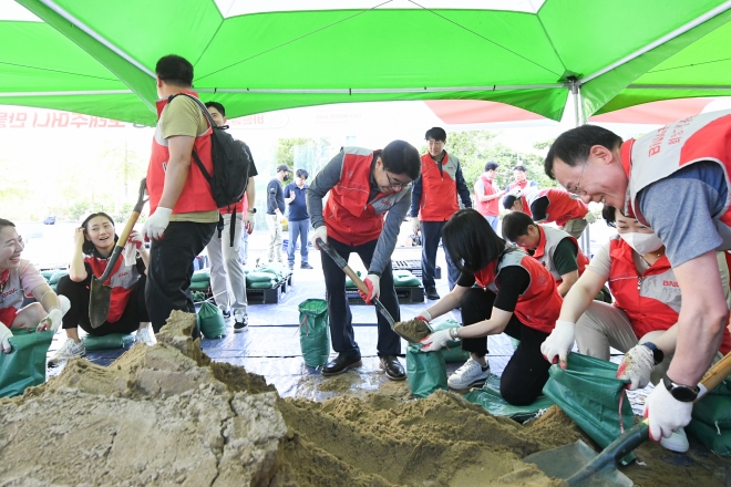 BNK부산은행 지역봉사단이 지난달 17일 수해 예방을 위한 물막이용 모래주머니를 제작하고 있다. 이날 봉사단은 부산시자원봉사센터를 통해 모래주머니 1500개를 상습 침수지역에 전달했다.  BNK부산은행 제공