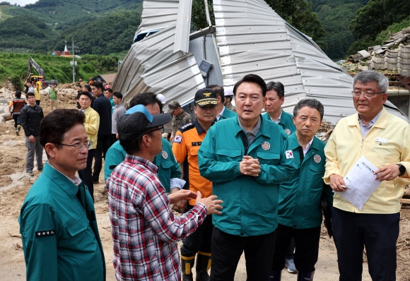 6박 8일간 순방을 마치고 귀국해 집중호우 대처 중앙재난안전대책본부 회의를 주재한 윤석열 대통령이 17일 경북 예천군 산사태 피해 현장을 살펴보며 지역 주민과 대화하고 있다. 2023.7.17 연합뉴스