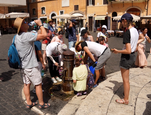사람들이 18일(현지시간) 이탈리아 로마의 판테온 근처 식수대에서 물을 받느라 에워싸고 있다. 로마 신화 연합뉴스