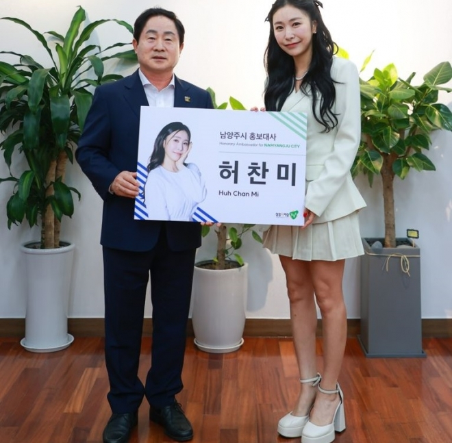 주광덕 시장이 18일 남양주 출신 트로트 가수 허찬미에게 홍보대사 위촉장을 주고 기념사진을 찍고 있다.  남양주시 제공